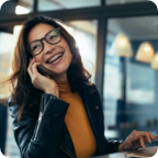Businessperson smiles while talking on a cellphone.